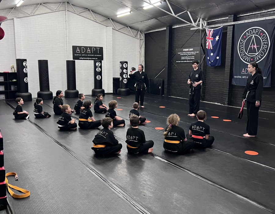 Rows of children sitting on karate mats